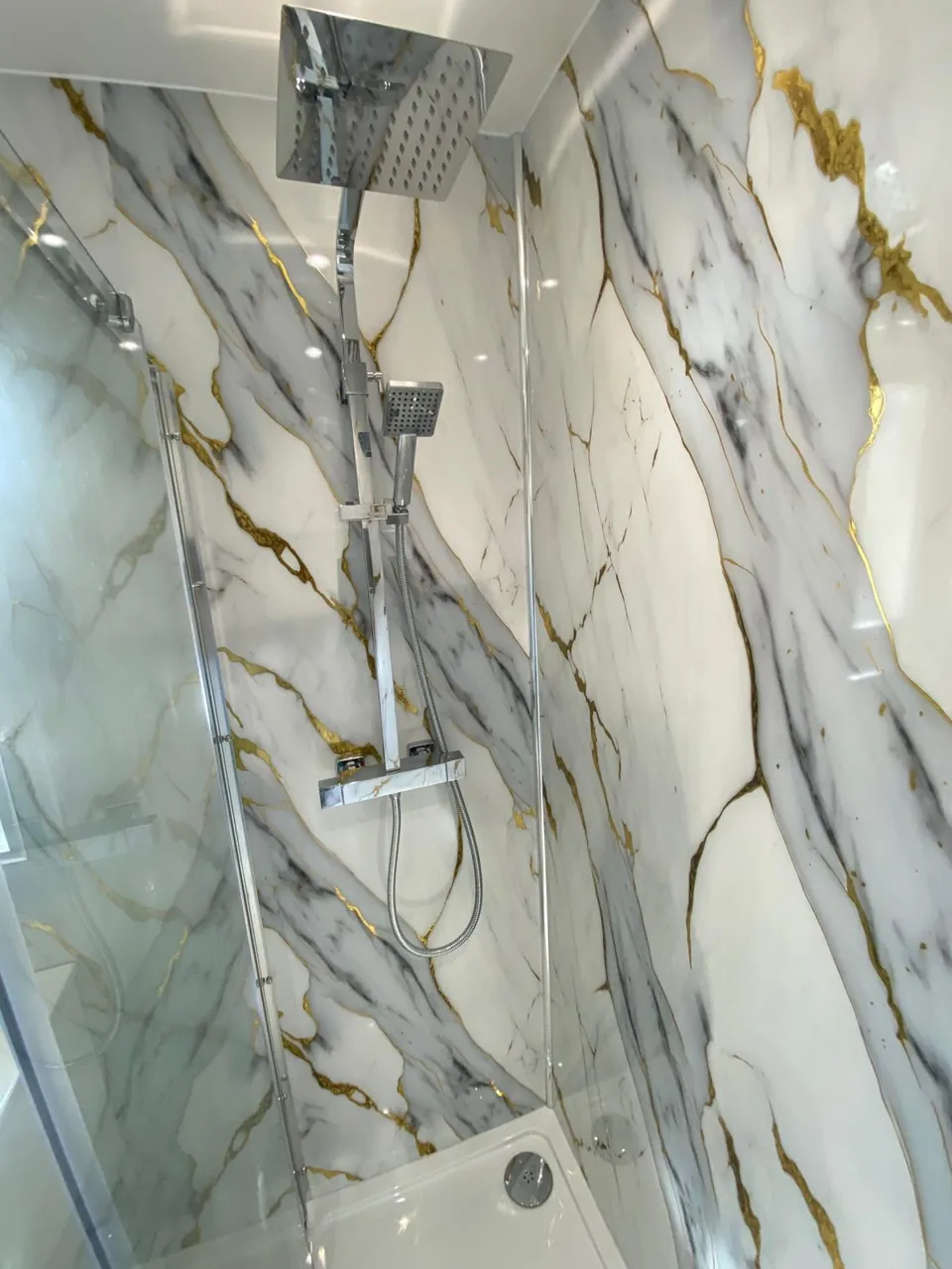 Shower enclosure and gold-veined marble-effect wall panels